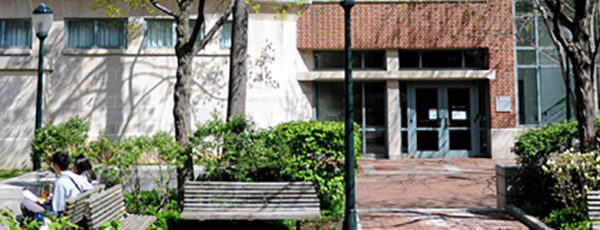 Photo of the Lauder-Fischer Hall with benches and trees in front of it