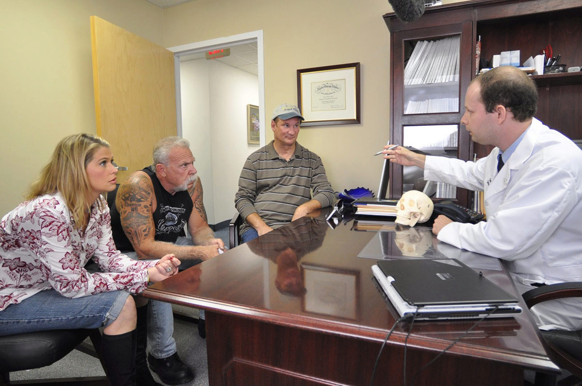 Three people meeting with a doctor in an office.