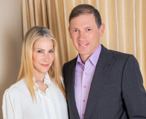Amanda and Glenn Fuhrman pose in business attire, standing next to each other.